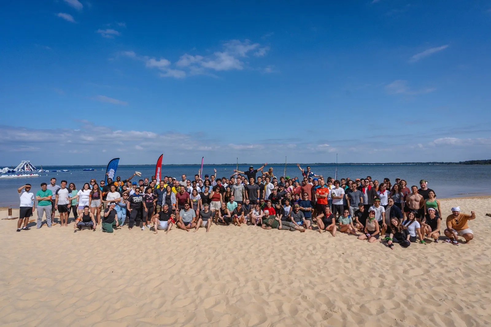 Les équipes Mobsuccess au complet sur une plage, alignées face à la mer par grand soleil.