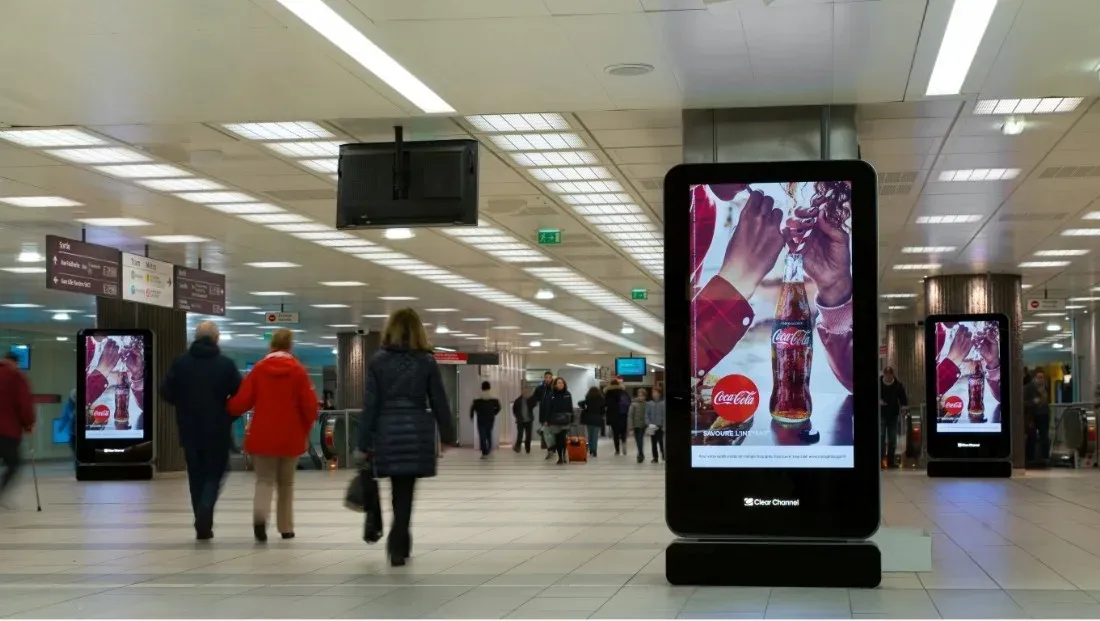 écrans publicitaires numériques dans un couloir de gare