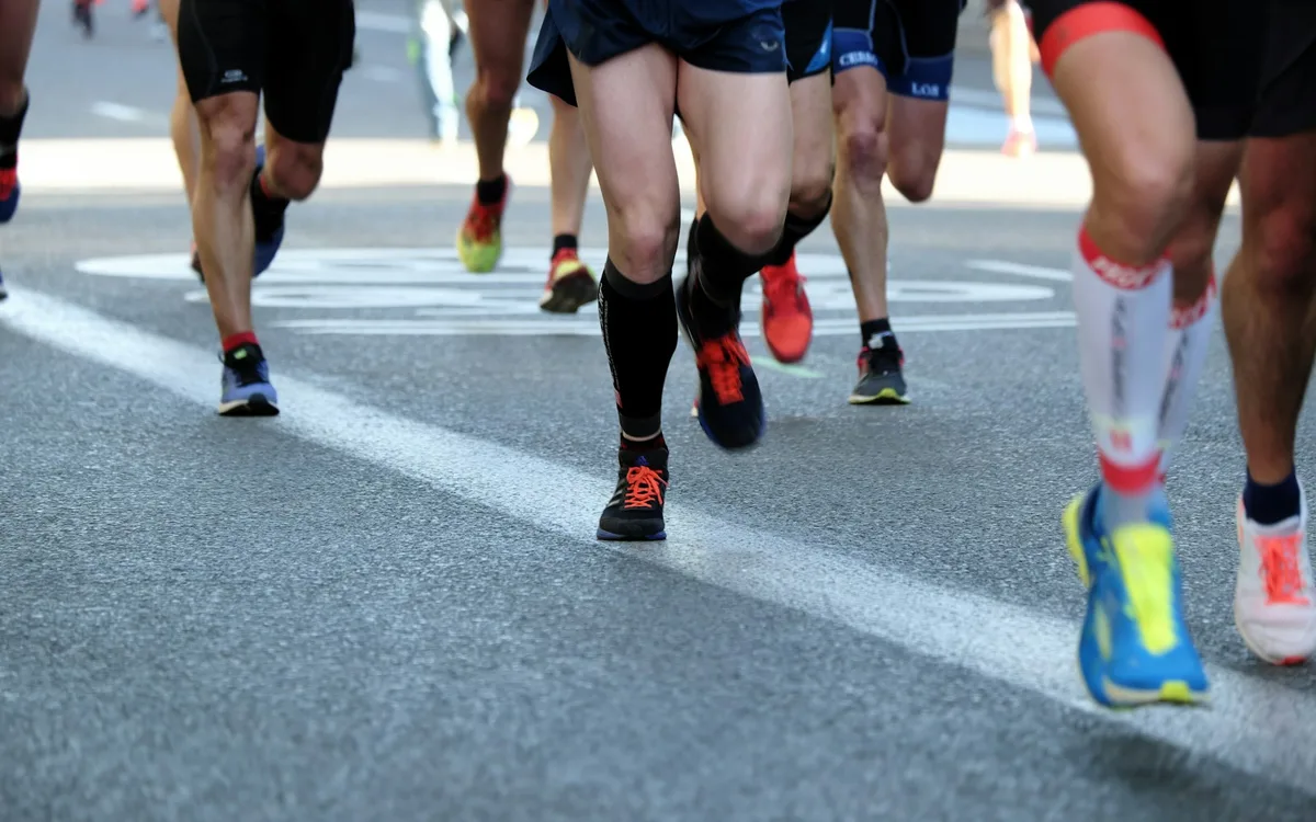 Runners' legs on a track, mid-race.